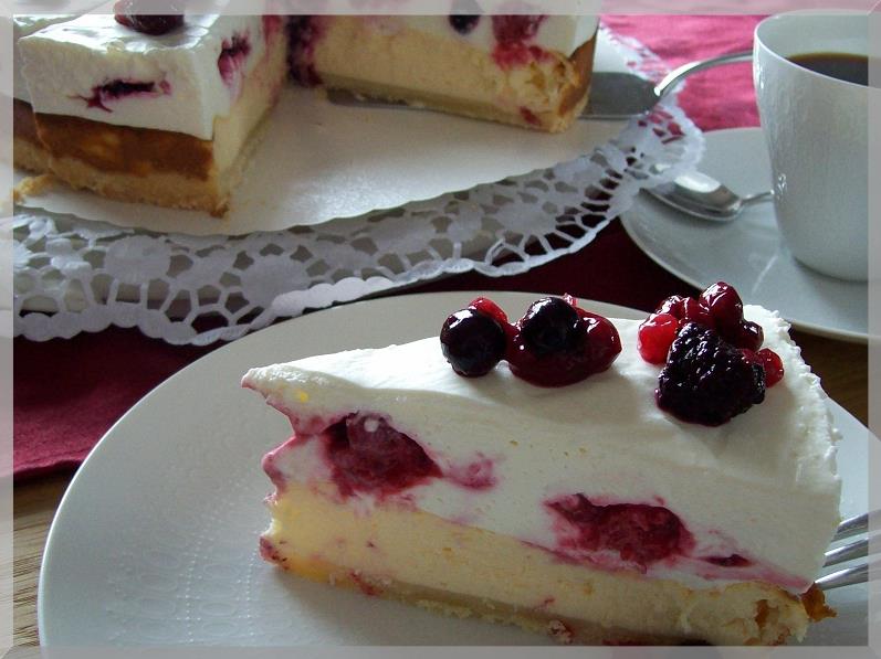 Käsekuchen mit Sahnehaube und Früchten